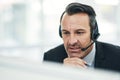 I see what you mean...a mature businessman using a headset while working on a computer in an office. Royalty Free Stock Photo