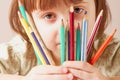 I see the world colored! Humorous photo of great artist. Portrait of cute little child girl with colored pencils