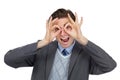 I see you. Playful image of an excited businessman pretending his hands are glasses - isolated.