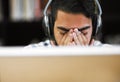 I seriously have to take a break. Closeup shot of a stressed out young man working on a computer while listening to Royalty Free Stock Photo