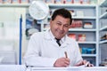 After I serve a customer I write it down. a male pharmacist working in a pharmacy. Royalty Free Stock Photo