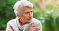 I should have brought something warmer. a carefree elderly woman seated on a bench while contemplating outside in a park Royalty Free Stock Photo