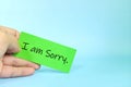 I am sorry message concept. Hand holding a bright yellow paper with written message note. Royalty Free Stock Photo