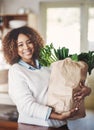I stock my home with the healthiest food. Portrait of a happy young woman holding a bag full of healthy vegetables at