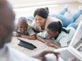 I sustain myself with the love of family. a family using s tablet while laying on the floor at home. Royalty Free Stock Photo