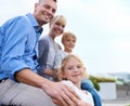 I sustain myself with the love of family. A happy two generation family smiling while outdoors.