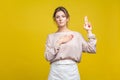 I swear! Portrait of faithful serious young woman with fair hair in casual beige blouse, isolated on yellow background