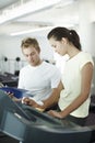 I think we can move you up a level. an attractive young woman working out with her personal trainer. Royalty Free Stock Photo