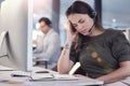 I think I need a break. a young female call center agent suffering from a headache at work.