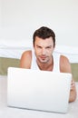 I think I should work from home today...A handsome man lying on his bed working on his laptop.