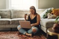 I think its time to top up on dog food. a young woman using a laptop and credit card in her living room at home. Royalty Free Stock Photo