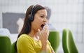 I think I need a coffee break. an attractive young female yawning at work.