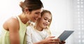 I think weve just found an app we both like. a beautiful young mother and her daughter using a digital tablet together