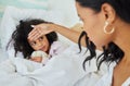 I think you have a fever. a young mother looking after her sick daughter at home.