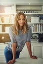 I took the first step. Portrait of a woman standing in front of bookshelves in her home office.