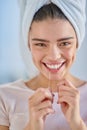 I value my smile. Cropped portrait of a beautiful young woman flossing her teeth in the bathroom at home. Royalty Free Stock Photo