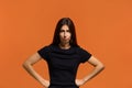 I am very angry. Portrait of serious caucasian woman in black t-shirt, holding hands on hip, frowning, having grumpy angry look, Royalty Free Stock Photo