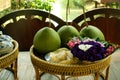 Three pomelos with flowers in wood basket