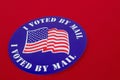 `I Voted By Mail` sticker on red background