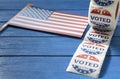 I Voted Today sticker with USA flag on blue wooden table. US presidential election