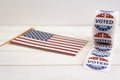 I Voted Today stickers and USA flag on white wooden table. US presidential election concept Royalty Free Stock Photo