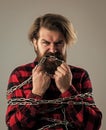 I want to be free. healthy teeth. brutal man with chain. chained up in chains. bearded man has aggressive look. express