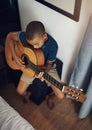 I want to be a guitarist just like my dad. a young boy playing the guitar at home. Royalty Free Stock Photo