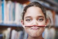 I want to go home and play. A cute young girl balancing her pencil on her lips and pulling a face.