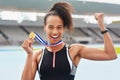 I was born to be a winner. Cropped portrait of an attractive young woman posing with her gold medal out on the track.