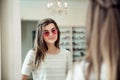 I will be most stylish woman on beach. Portrait of attractive caucasian young brunette standing in optician store Royalty Free Stock Photo