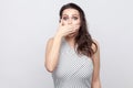 I will be silence. Portrait of shocked beautiful young brunette woman with makeup and striped dress standing with big eyes and