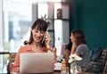 I will get back to you. an attractive middle aged woman talking on her cellphone while working on a laptop inside of a Royalty Free Stock Photo