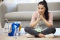 I wish the chores could do themselves. Shot of a young woman looking bored sitting on the floor while doing chores at Royalty Free Stock Photo