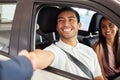 I wish you many happy miles in your new car. a young couple leaving a car dealership with their new car. Royalty Free Stock Photo