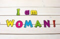 I am Woman! Positive affirmation, statement. Bold neon letters on white wood table