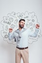 I won! Happy young man is celebrating his success with raised hands while standing against grey background with Royalty Free Stock Photo