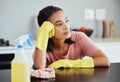 I wonder if ill ever finish cleaning. a young woman taking a break form cleaning her kitchen.