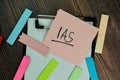 IAS write on sticky notes isolated on Wooden Table