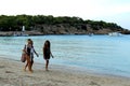 Three women walking next to seashore on the famous and touristic beach of Ibiza island