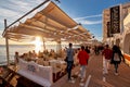 Crowds of people meet the sunset at the seafront terrace of Savannah cafe