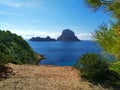 Ibiza and its wonders. the crystal blue sea, the islet of Es Vedra seen from the cliffs of Cala D`Hort in a blue summer tourist