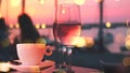 cup of coffee and two glass of wine people silhouette drink orange wine on beach cafe at romantic pink sunset evening on sea Royalty Free Stock Photo