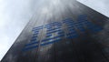 IBM logo on a skyscraper facade reflecting clouds. Editorial 3D rendering Royalty Free Stock Photo