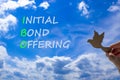 IBO initial bond offering symbol. Concept words IBO initial bond offering on beautiful blue sky clouds background. Wooden bird.