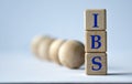 IBS - acronym on a wooden block on a white background with wooden balls