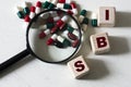 IBS - a word on cubes on a light background with a magnifying glass and tablets