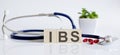 IBS the word is written on wooden cubes and sthetoscope and piils . Medicine