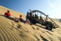 ICA, PERU - JULY 6, 2010: Sand dune buggy parked on a dune and group of people having fun. Ica, Peru Royalty Free Stock Photo