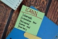 ICANN - Internet Corporation for Assigned Names and Numbers write on sticky notes isolated on Wooden Table