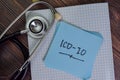 ICD-10 write on sticky notes isolated on Wooden Table Royalty Free Stock Photo